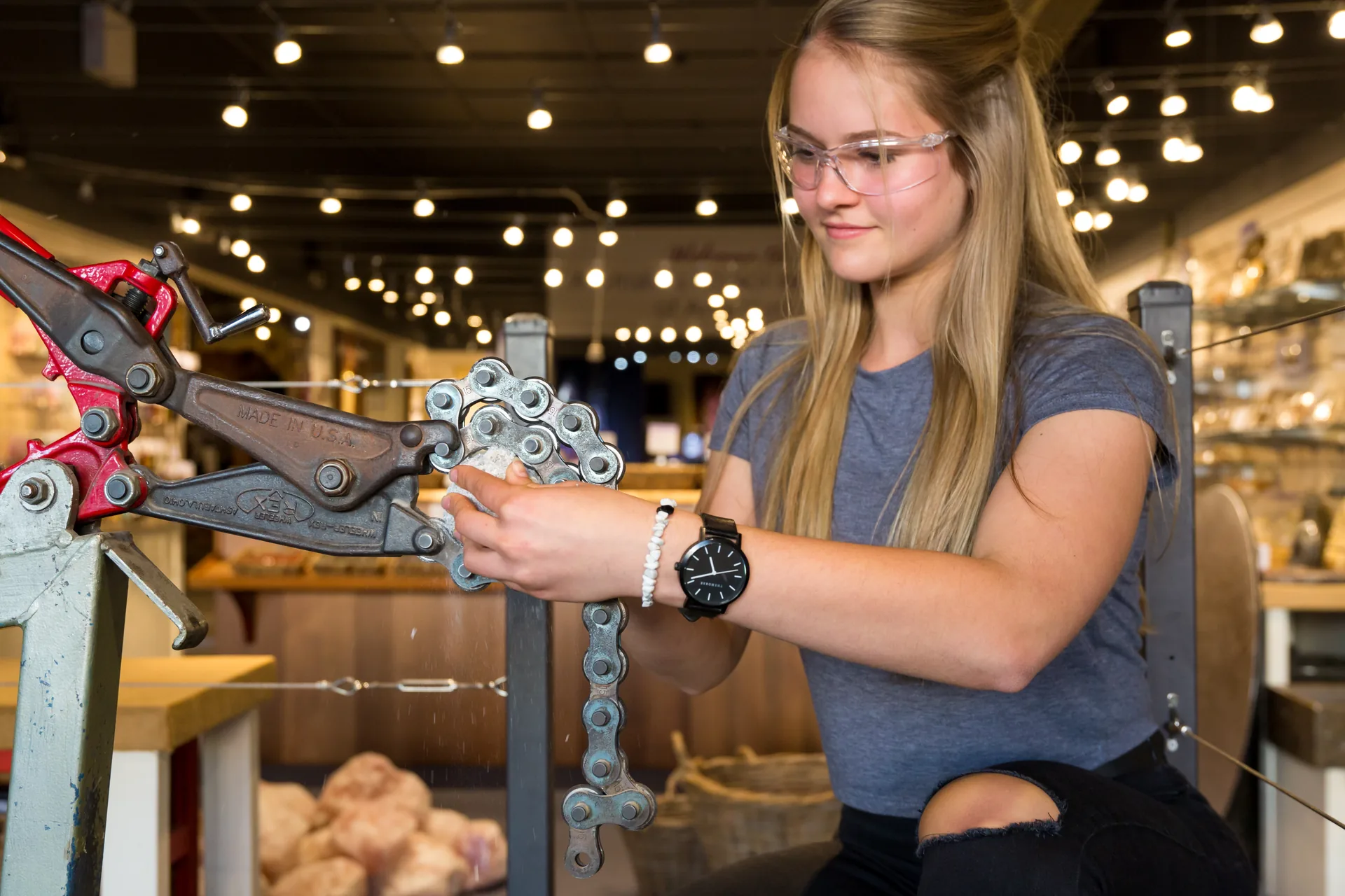 A visitor with safety glasses loading a geode into the cracker at Crystal Caves