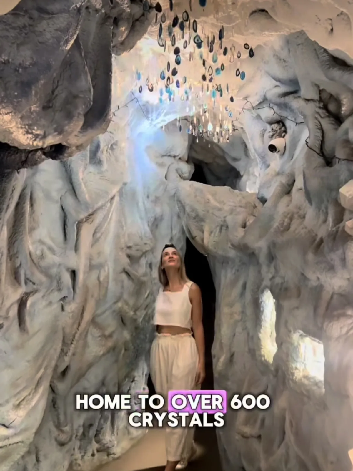 Reel: a visitor beneath the agate chandelier — home to over 600 crystals