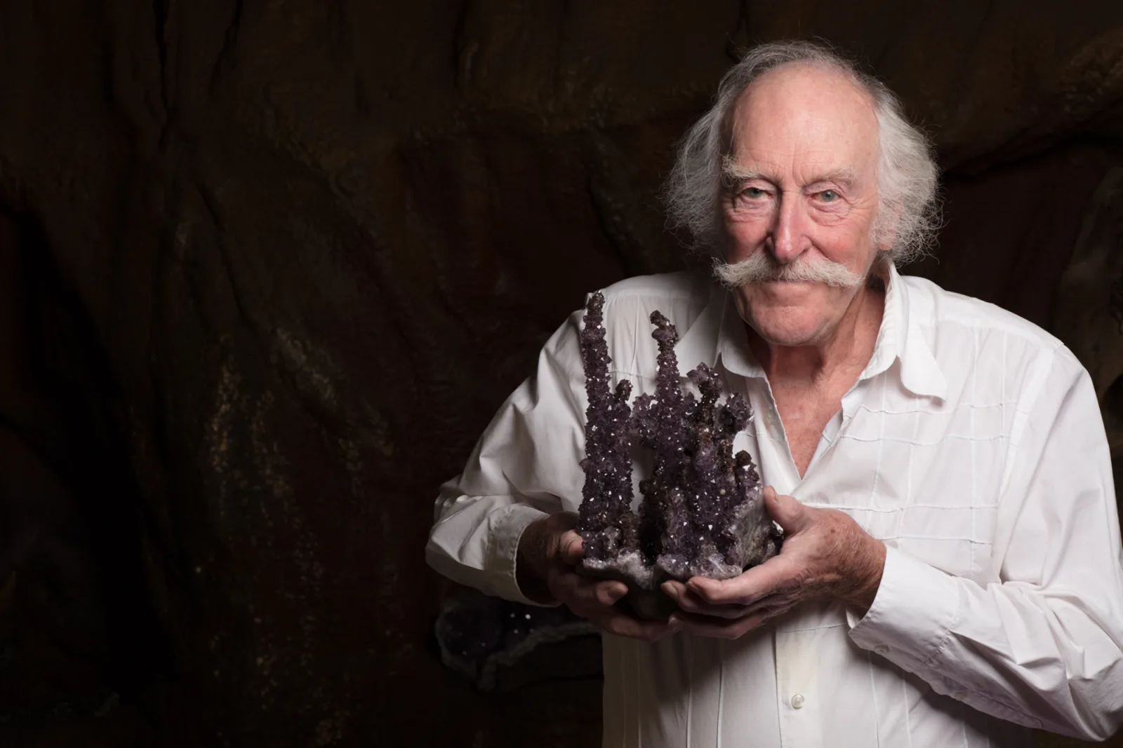 René Boissevain holding an amethyst stalagmite cluster inside the Crystal Caves